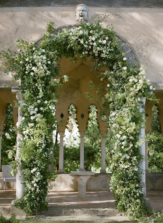 Arco di fiori in stile naturale e spontaneo con rami verdi e fiori bianchi