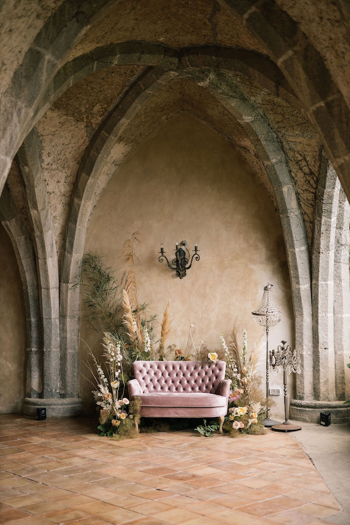 Photo booth for boho chic wedding with pink velvet sofa