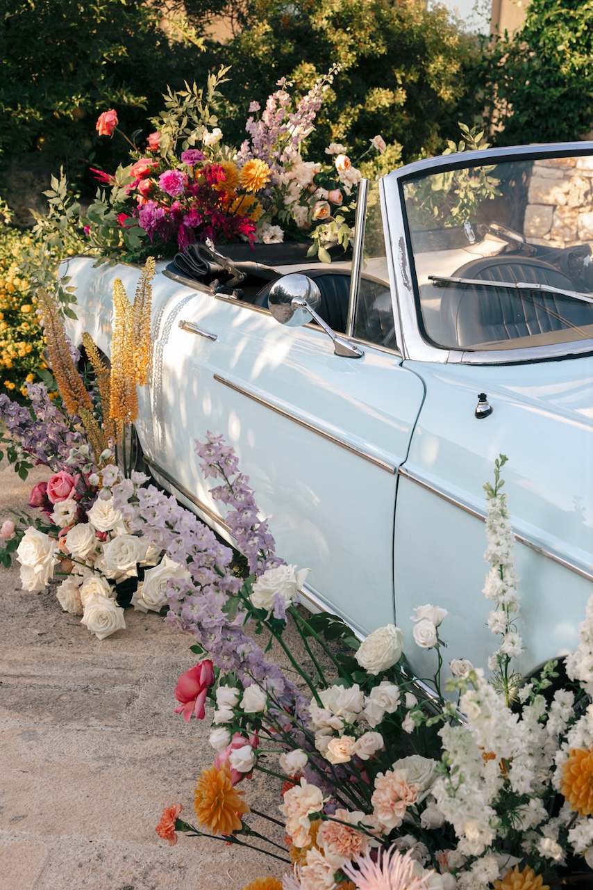 wedding car with spontaneous growth with white roses and colorful flowers