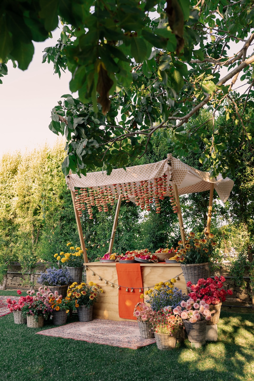 bangles ceremony stall with colorful flowers baskets and orange carnation garlands