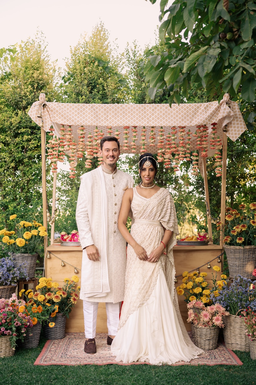 indian wedding with traditional clothes and orange carnation garlands