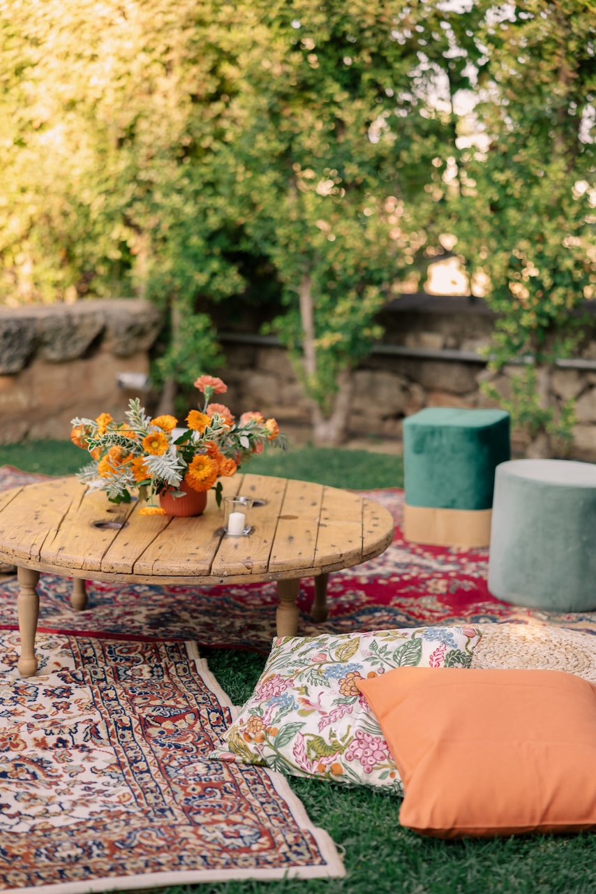 indian ceremony with traditional carpets and orange flower centerpieces