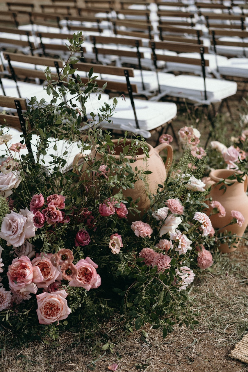 dettaglio floreale con rose, verde e vasi in terracotta per cerimonia nuziale all'aperto in Masseria Pettolecchia