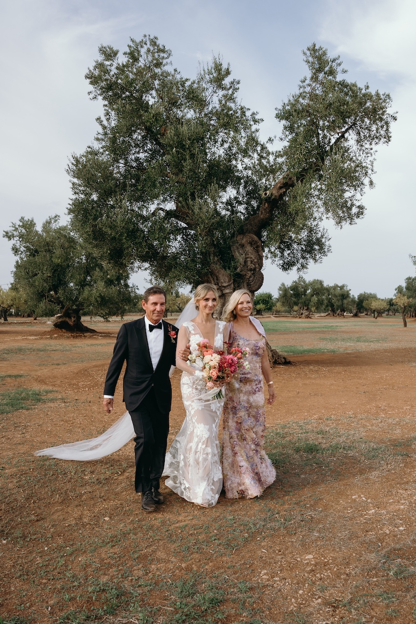 arrivo della sposa con bouquet alla cerimonia nuziale all'aperto